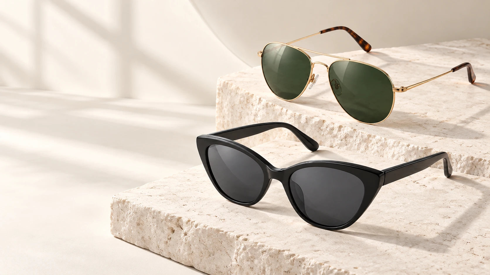 Gold aviator and black cat-eye sunglasses on limestone